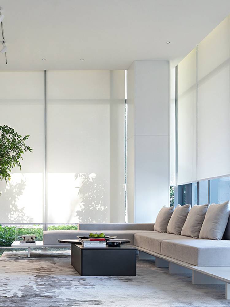 Light-colored roller shades lowered across windows in a modern living room